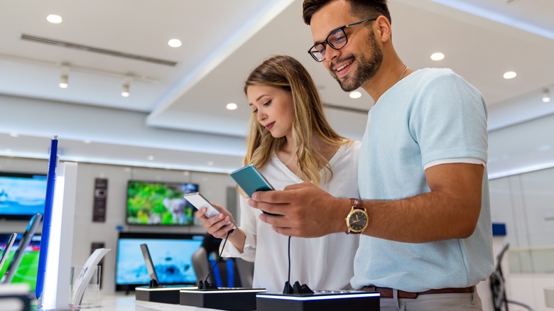 People testing different smartphones at the store