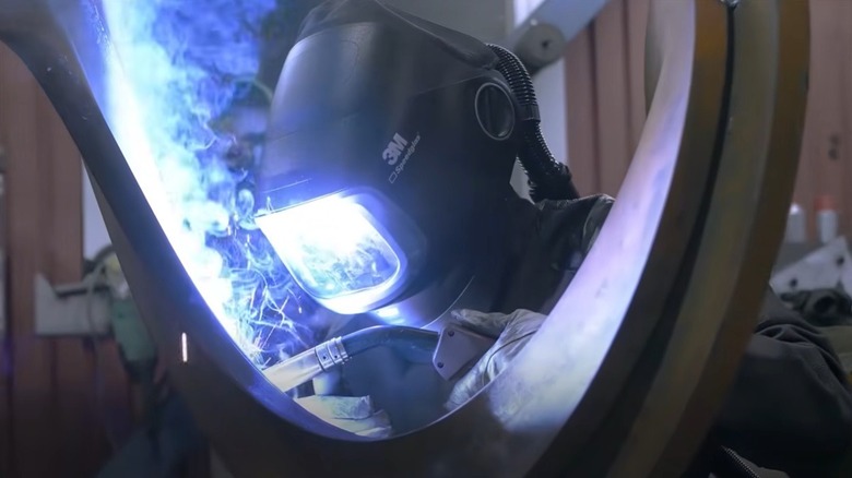 Person welding metal while wearing Speedglas welding helmet