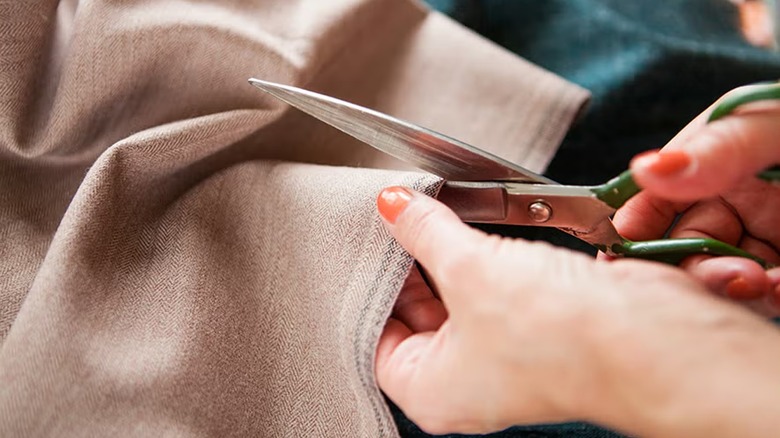 Using a Klein Cutlery scissor to cut a cloth.