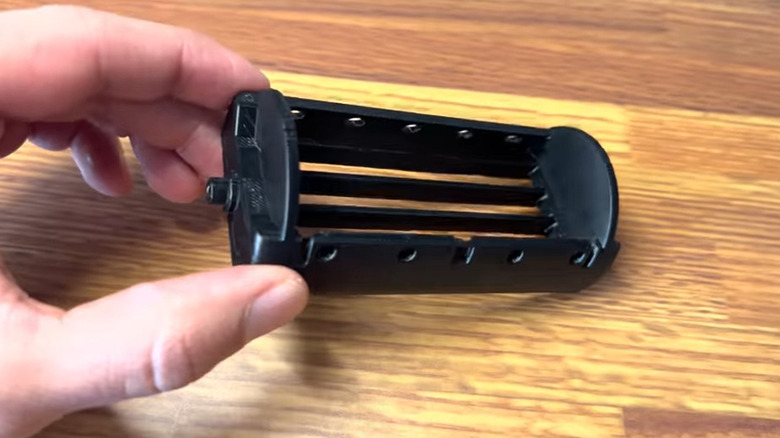 Hand holding a black 3D printed AC/heat vent for a Land Cruiser