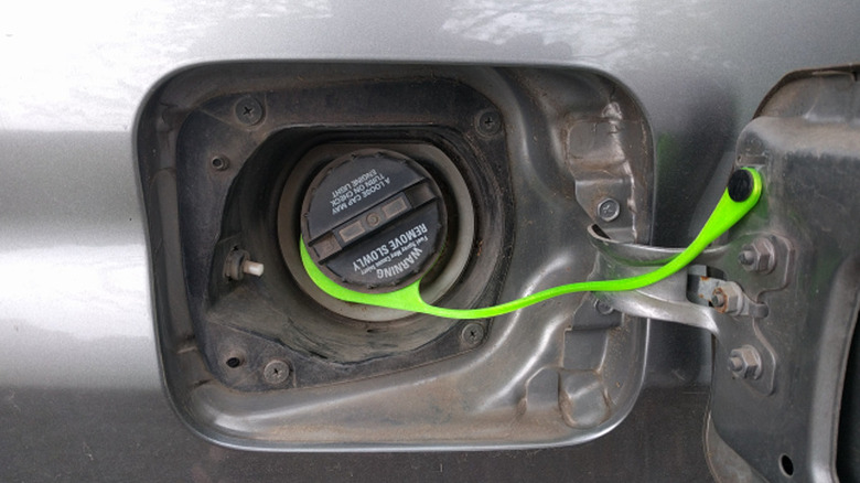 Green 3D printed gas cap tether attached to a vehicle's gas gap