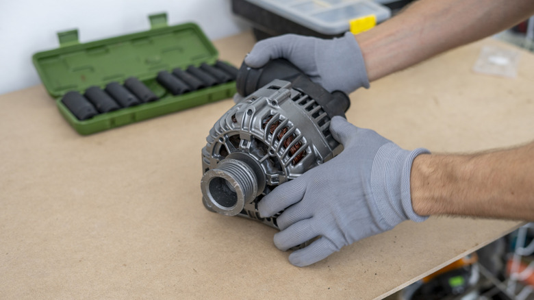 Close up of a mechanic looking at an alternator
