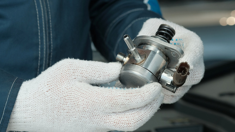 Close up of a mechanic holding a fuel pump
