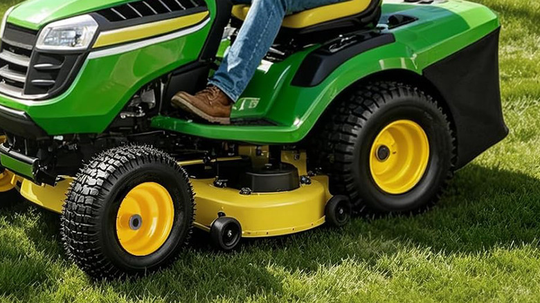 A John Deere lawnmower with a fresh set of tires on it.