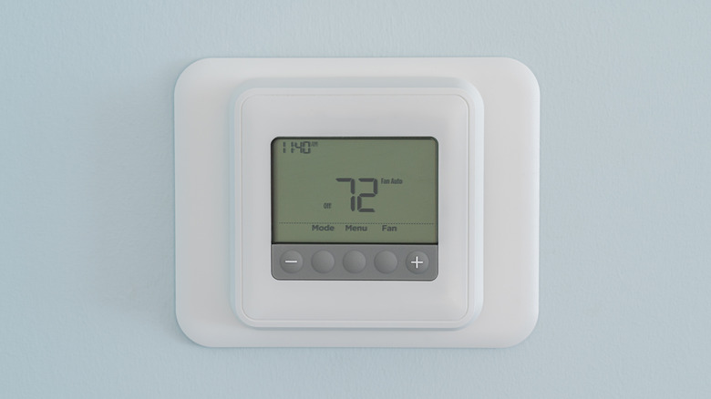 Rectangular shaped thermostat control showing 72 on a wall