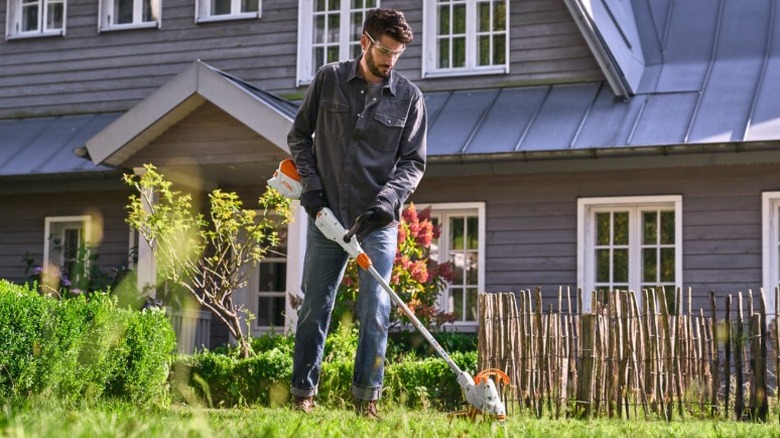 Person using a Stihl FSA 50 grass trimmer to trim grass