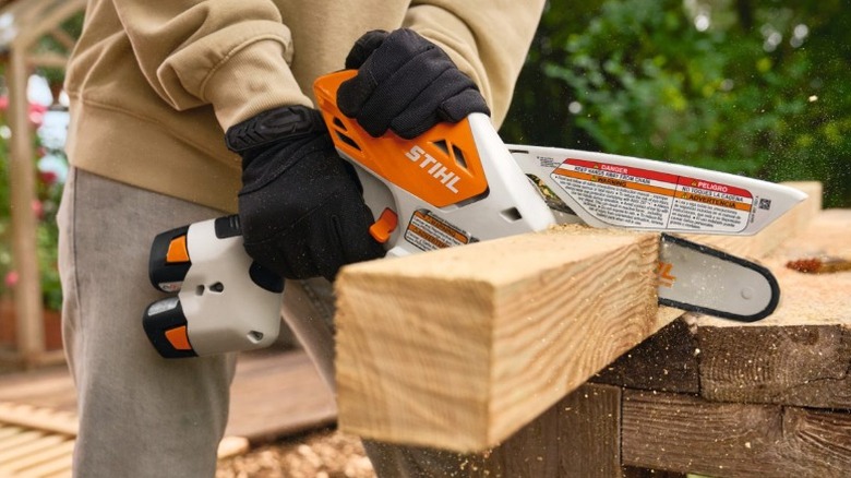 Person cutting through a piece of wood using a Stihl GTA 30 pruner