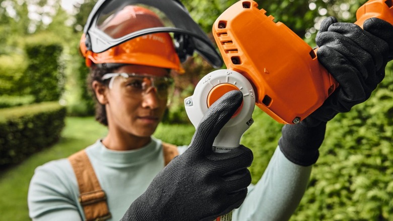 Close-up of a person operating a Stihl HLA 40 hedge trimmer