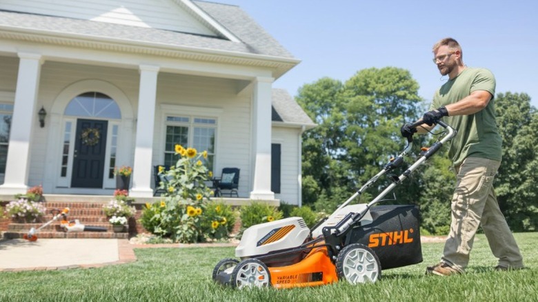 Person using a Stihl RMA 348 V push mower to mow a lawn