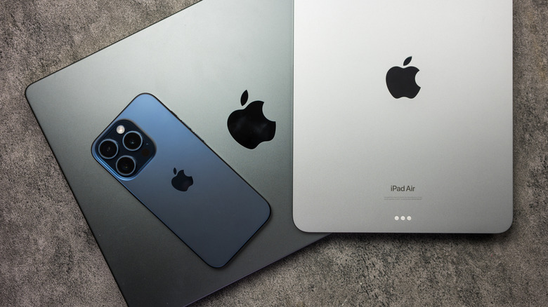 An iPhone and an iPad placed on a MacBook