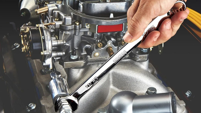 A man using an Icon branded wrench on a car engine