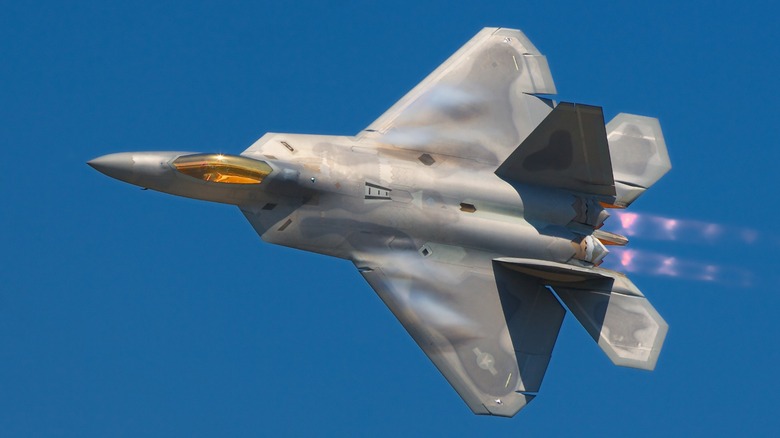 An F-22 Raptor flying over blue skies