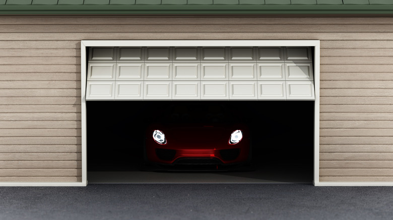 Garage door opening to reveal a car's headlights