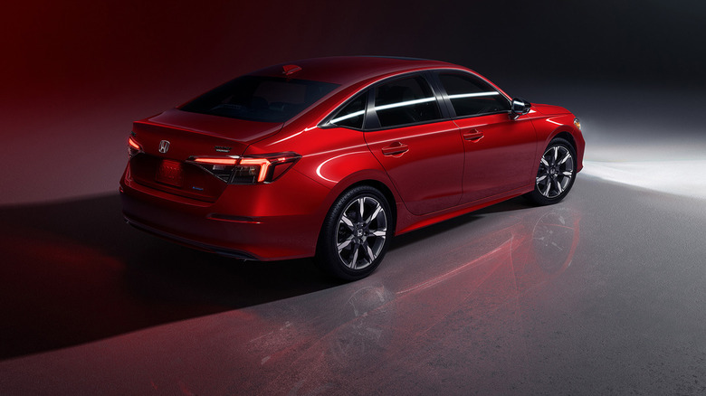 A red Honda Civic in a dark garage.