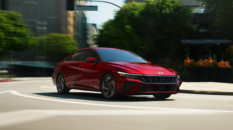 A red Hyundai Elantra driving around a city street