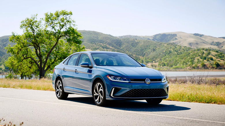 A blue gray Volkwasgen Jetta on a country road