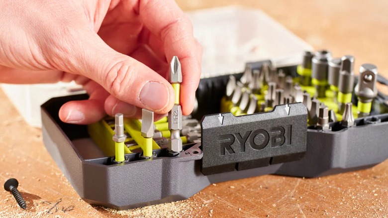 A close-up of a hand removing a Phillips drill bit from a Ryobi bit set