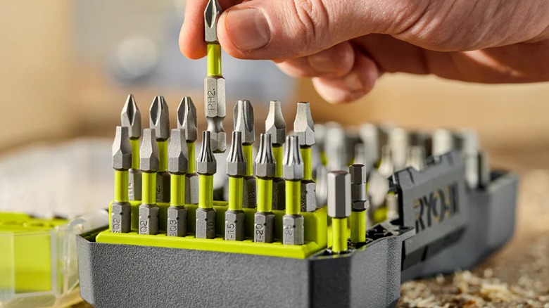 A hand pulling a Phillips bit from a Ryobi bit set