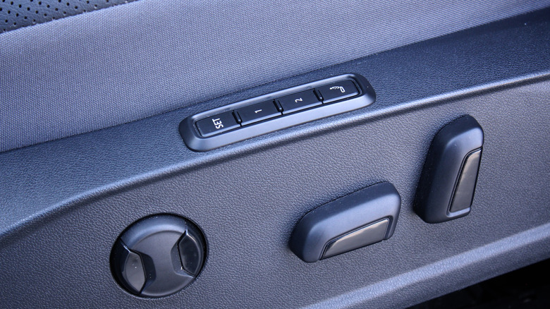 A view of memory seat recall buttons on a car's door panel.