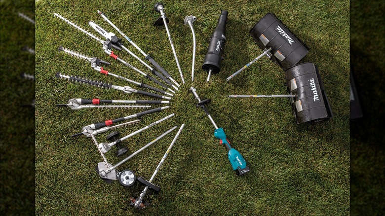 Makita Cordless Couple Shaft Attachments laid out on a lawn