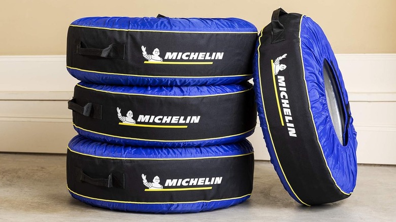 Three tires in Michelin tire covers stacked up with one tire leaning against the stack