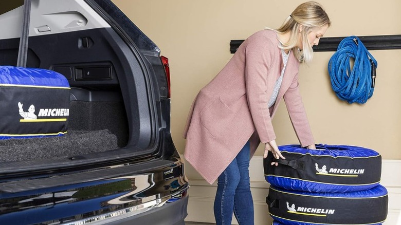 Person moving tires protected in Michelin tire covers