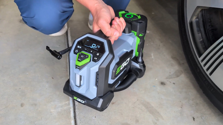 The new POWER+ Compact Inflator next to a vehicle tire