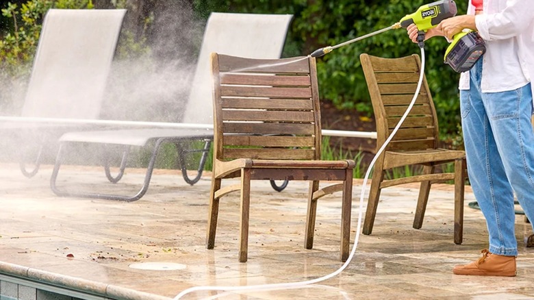Woman using Ryobi PCLPC07K Pressure Cleaner on wood chairs