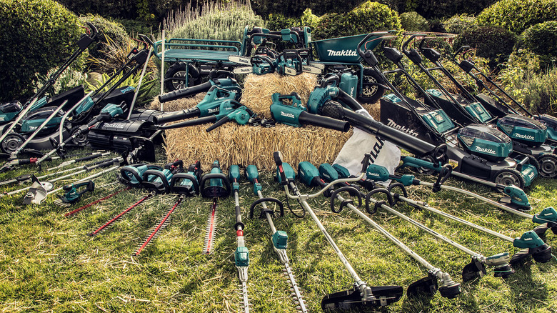 Dozens of Makita-branded yard tools posed on green grass.