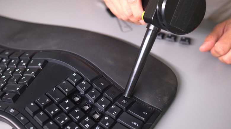 A person outside the view of the camera uses an air duster on a keyboard.