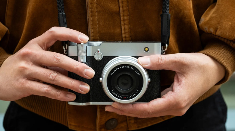A person holding the Fujifilm GFX100RF