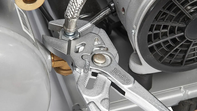 An Icon branded pliers wrench tightening a water hose.