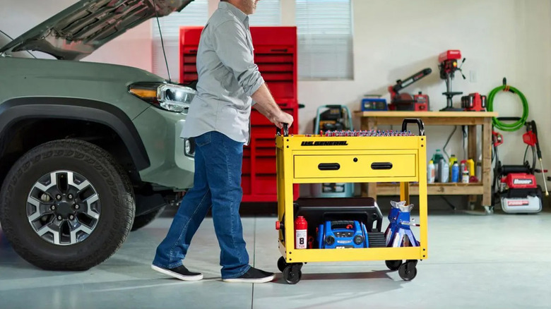 A yellow service cart being pushed in a garage