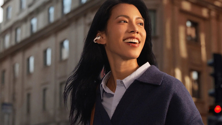 Dark haired woman smiling and wearing the Baseus Inspire XC1.