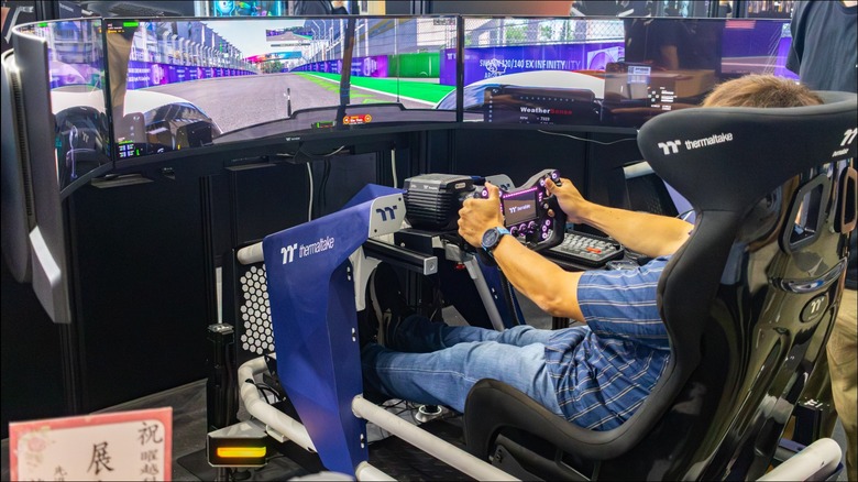 The Thermaltake GR900 racing sim rig with a person driving on the racing simulator