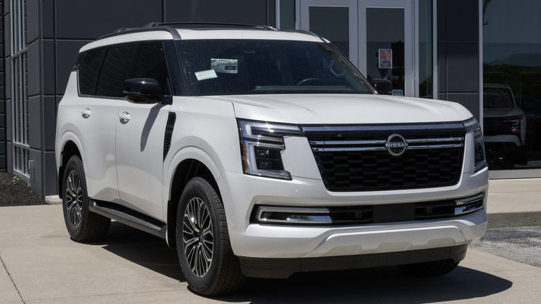A white Nissan Armada parked in front of a building