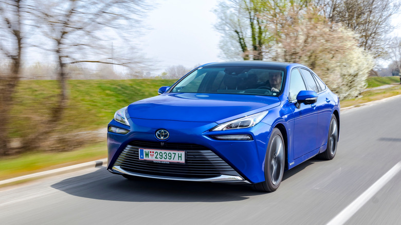 Blue Toyota Mirai speeding down a road