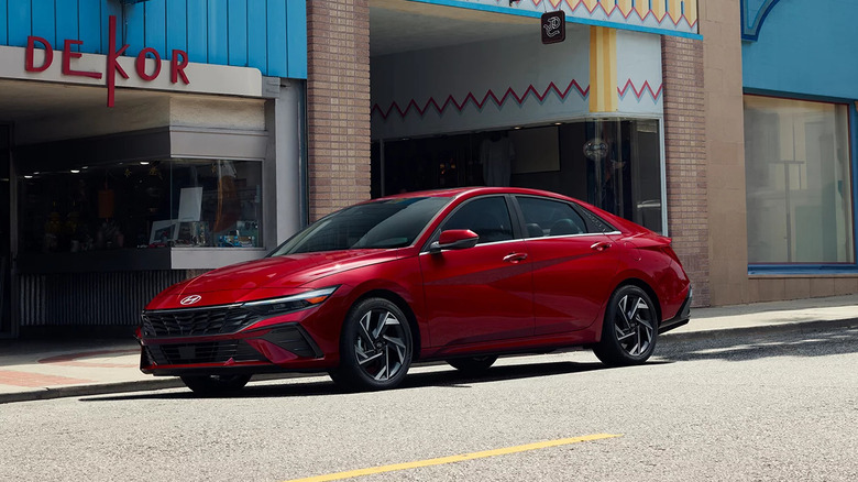 A red 2026 Hyundai Elantra parked outside a shopping complex