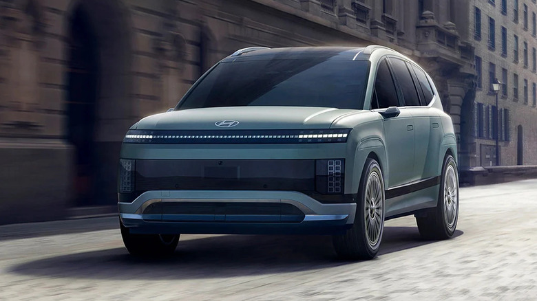 A 2026 Ioniq 9 speeding past a row of buildings