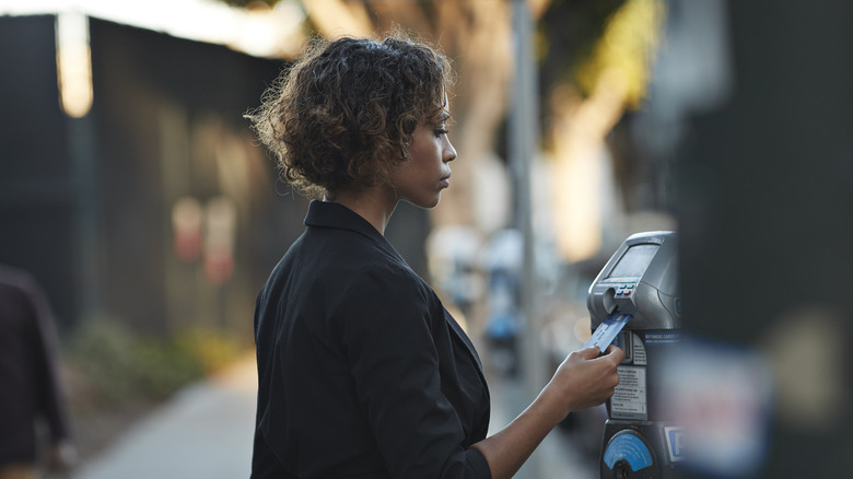 woman paying at a parking meter