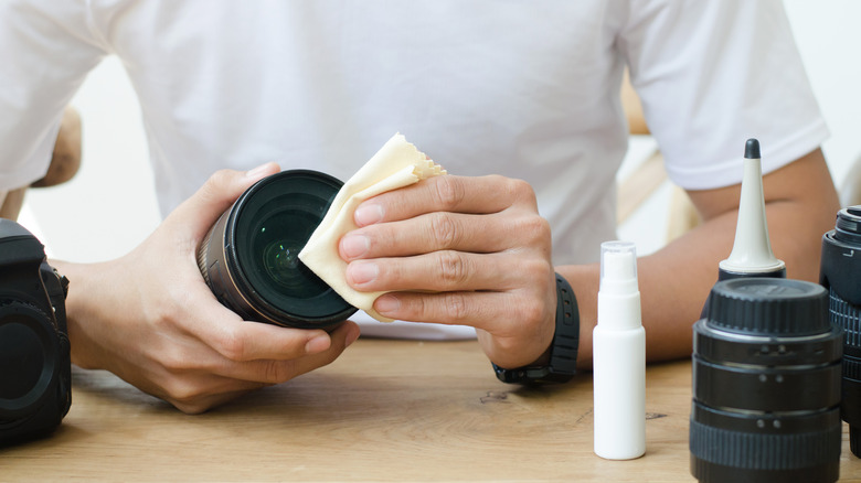 Photographer wiping a lens