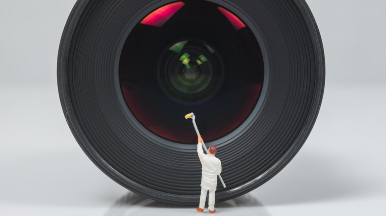 man cleaning a giant lense