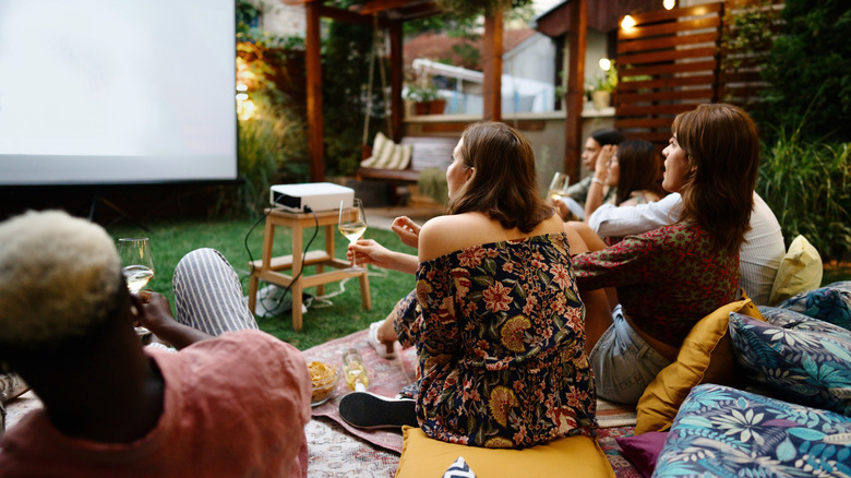 Family watching a movie in a backyard
