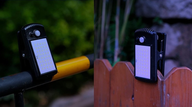 Two LED lights clipped onto a fence and rail