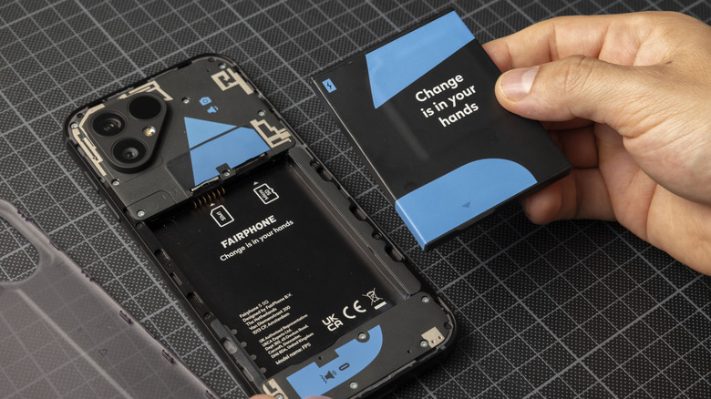 Picture of a person removing the Fairphone battery from the phone.