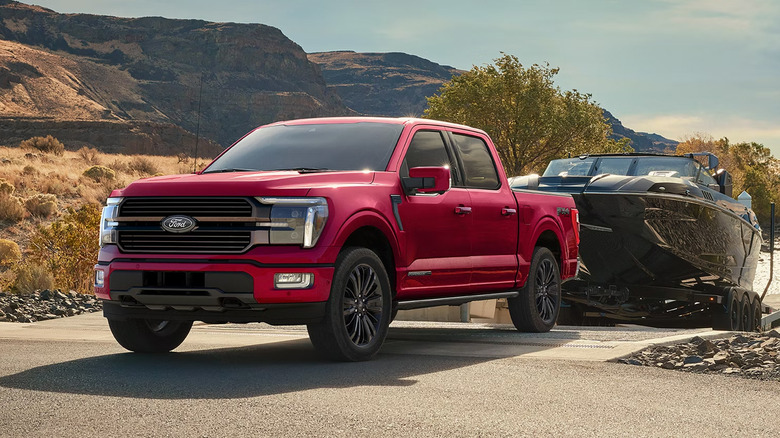 A red 2026 Ford F-150 towing a boat