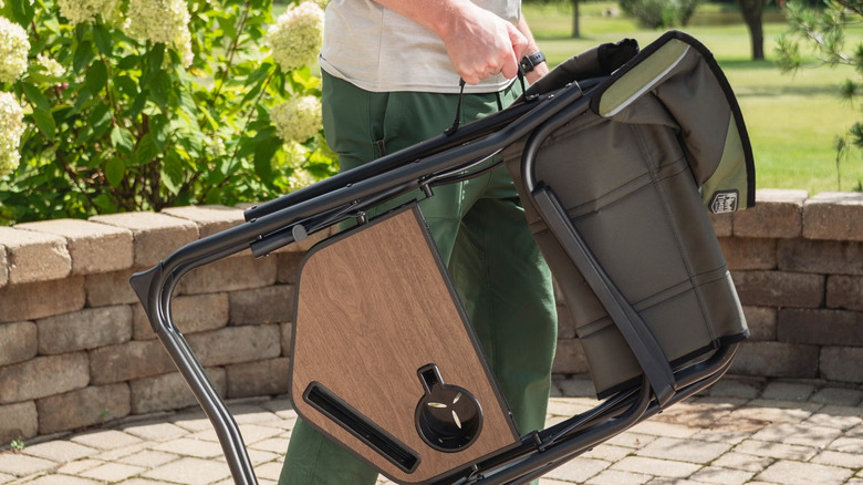 Person carrying Timber Ridge chair