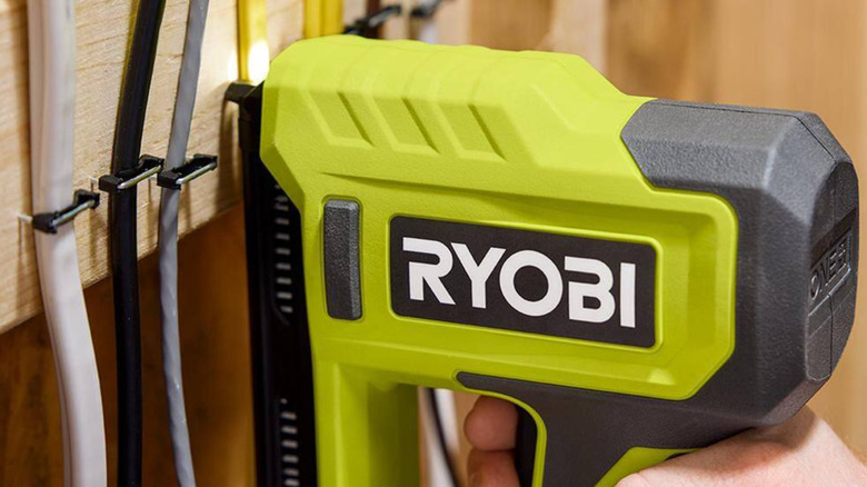 Closeup of the Ryobi Cordless Cable Stapler in use.
