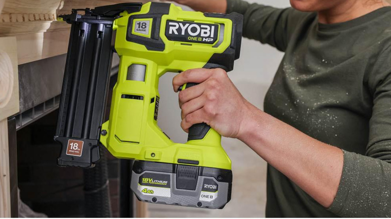 A person using the One+ HP 18V Brushless Cordless Nailer in a home project.