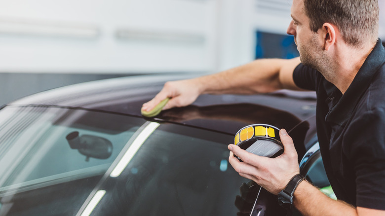 A person applying wax with a microfiber cloth